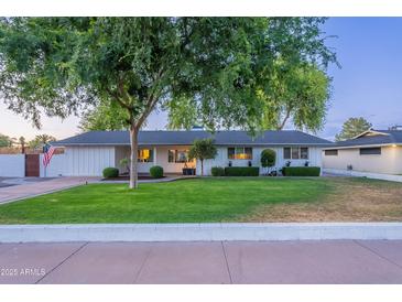 Charming single-story home with a well-manicured lawn and mature tree offering plenty of curb appeal at 3002 E Mitchell Dr, Phoenix, AZ 85016