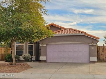 Charming single-story home featuring a spacious two-car garage, complemented by a well-manicured lawn and mature tree at 4043 E Arbor Ave, Mesa, AZ 85206