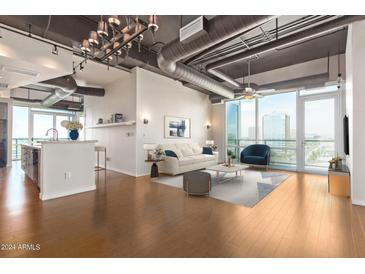 Open living area with hardwood floors, city views, and modern furniture at 1 E Lexington Ave # 908, Phoenix, AZ 85012