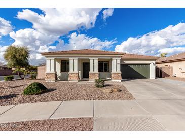 Charming single-story home with a well-maintained front yard and a two-car garage at 18906 E Cattle Dr, Queen Creek, AZ 85142