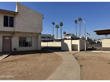 A view of the apartment complex exterior with a sidewalk and palm trees at 3840 N 43Rd Ave # 75, Phoenix, AZ 85031