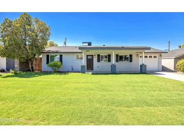 Cute ranch style home with a covered porch and well-manicured lawn at 4825 E Piccadilly Rd, Phoenix, AZ 85018