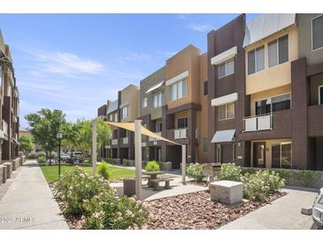 Modern community with courtyard, green space, and shaded seating areas at 6605 N 93Rd Ave # 1087, Glendale, AZ 85305