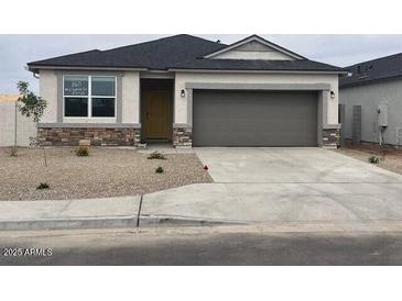 Charming single-story home featuring stone accents, a two-car garage, and low maintenance desert landscaping at 97 S Collier Ln, Casa Grande, AZ 85122