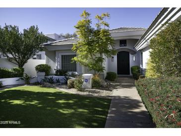 Beautiful single-story home with landscaped front yard and walkway at 10040 N 78Th Pl, Scottsdale, AZ 85258