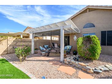 A well landscaped backyard includes trimmed bushes, rock ground cover and a covered outdoor space at 17202 N Javelina Dr, Surprise, AZ 85374