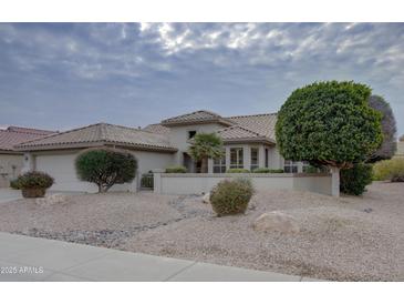 Single-story home with a tile roof, landscaped yard, and a two-car garage at 17733 N Escalante Ln, Surprise, AZ 85374
