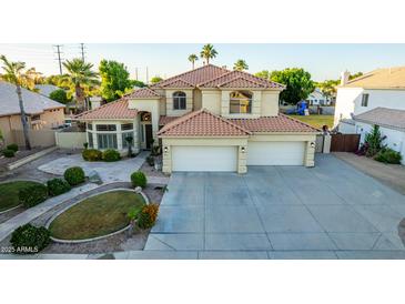Two-story house with tile roof, three-car garage, and landscaped yard at 2042 E Victor Rd Rd, Gilbert, AZ 85296