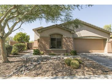 Inviting single-story home featuring a desert-landscaped yard, a two-car garage, and a charming front entrance at 2335 W Muirfield Dr, Anthem, AZ 85086