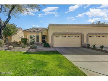 Beautiful desert landscape home with two-car garage and grassy yard at 19504 N 88Th Dr, Peoria, AZ 85382