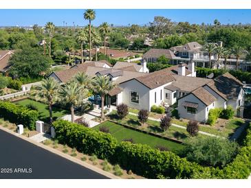 Stunning aerial view of a sprawling home with lush landscaping, pool, and palm trees in a desirable neighborhood at 6235 E Montecito Ave, Scottsdale, AZ 85251