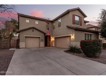 Two-story house with attached garage, landscaping, and a flag at 739 E Lovebird Ln, Gilbert, AZ 85297