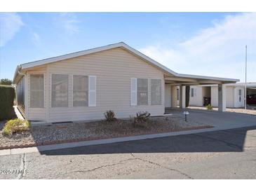 Tan single-story home with carport and landscaping at 215 N Power Rd # 440, Mesa, AZ 85205