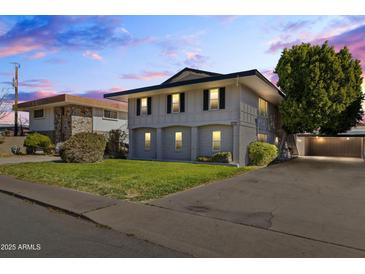 Two-story house with gray exterior, landscaping, and driveway at 6547 N 3Rd Ave, Phoenix, AZ 85013