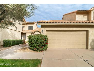 Attractive condo exterior with a two-car garage and well-maintained landscaping at 7760 E Pepper Tree Ln, Scottsdale, AZ 85250