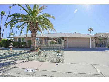 Well-maintained single-story home with a landscaped front yard and two-car garage at 10701 W Pineaire Dr, Sun City, AZ 85351