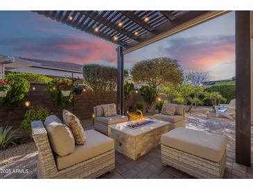 Cozy patio with a fire pit and comfortable seating, perfect for relaxing evenings under the pergola lights at 189 E Atacama Ln, Queen Creek, AZ 85140