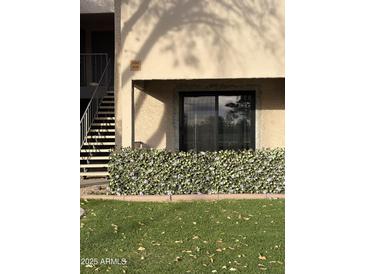 Exterior view of building with artificial hedge and stairs at 1920 W Lindner W Ave # 108, Mesa, AZ 85202