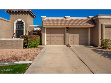 Two-car garage with Spanish-style architecture and landscaping at 25239 S Glenburn Dr, Sun Lakes, AZ 85248