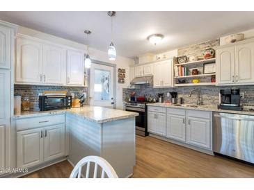 Updated kitchen with white cabinets, granite counters, and island at 3640 N 21St Ave, Phoenix, AZ 85015