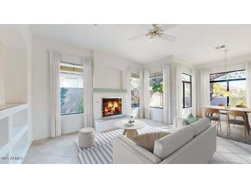 Cozy living room with a fireplace, ample natural light, and access to the dining area at 8227 E Sierra Pinta Dr, Scottsdale, AZ 85255