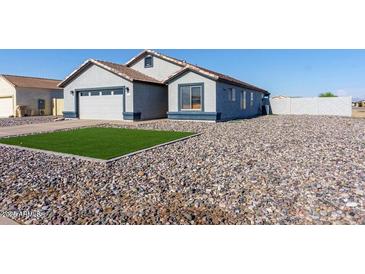 House exterior features a two-car garage and artificial turf at 15281 S Capistrano Rd, Arizona City, AZ 85123