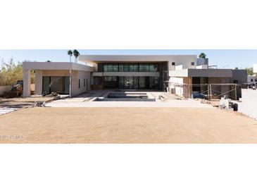 Modern home exterior with expansive backyard, pool, and large windows at 7432 E Wethersfield Rd, Scottsdale, AZ 85260