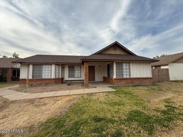 Single story home with brick facade and grassy front yard at 8520 W Palm Ln # 1021, Phoenix, AZ 85037