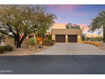 Desert landscape home with stucco exterior, two-car garage, and mature trees at 1300 Coyote Pass --, Carefree, AZ 85377