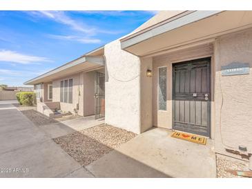 Inviting front exterior with neutral stucco, covered entry, and low maintenance rock landscaping at 2533 W Hazelwood St # 3, Phoenix, AZ 85017