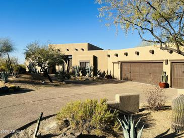 Beautiful stucco home with a three-car garage and desert landscaping at 9950 E Sundance Trl, Scottsdale, AZ 85262