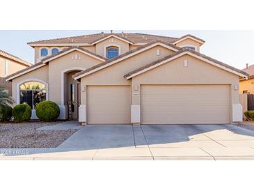 Two-story house with beige exterior, three-car garage, and landscaping at 43615 W Roth Rd, Maricopa, AZ 85138