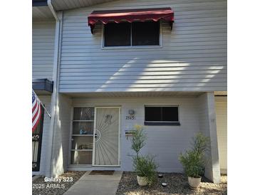 Well-maintained townhouse with attractive landscaping and a red awning at 2545 W Rose Ln # A-2, Phoenix, AZ 85017