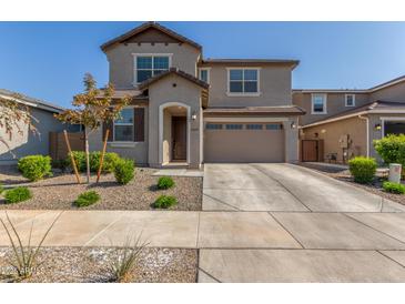 Two-story house with tan exterior, two-car garage, and landscaping at 26049 S 230Th St, Queen Creek, AZ 85142