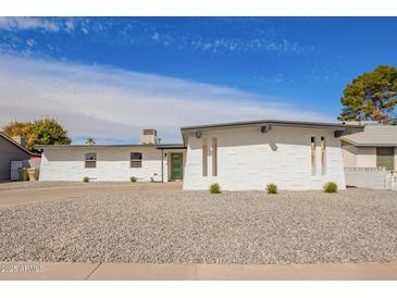 Charming white brick home featuring desert landscaping and a contemporary design at 5528 W Sunnyslope Ln, Glendale, AZ 85302