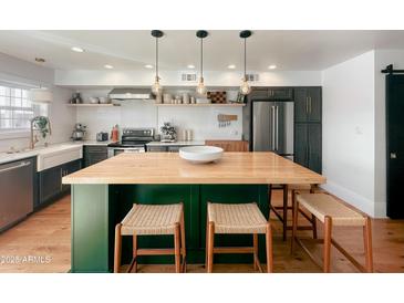 Modern kitchen with butcher block island, stainless steel appliances, and white shaker cabinets at 1425 E Desert Cove Ave # 24, Phoenix, AZ 85020