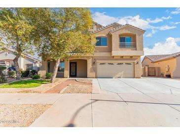 Two-story house with tan exterior, landscaped yard, and a two-car garage at 2315 S 173Rd Dr, Goodyear, AZ 85338