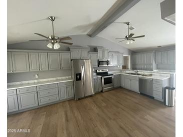 Spacious kitchen with gray cabinets, stainless steel appliances and hardwood floors at 1324 W Bethany Home Rd, Phoenix, AZ 85013