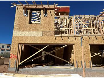 Exterior of new home under construction featuring wood framing and an open garage space on a sunny day at 21048 N 58Th St, Phoenix, AZ 85054