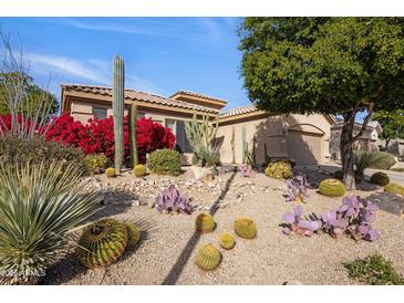 Landscaped front yard with desert plants and cacti surrounding a tan single-story home at 7654 E Quill Ln, Scottsdale, AZ 85255