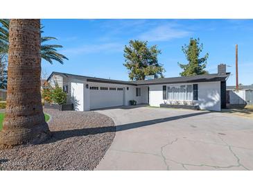 Updated mid-century modern home with a landscaped front yard and two-car garage at 8626 E Montebello Ave, Scottsdale, AZ 85250