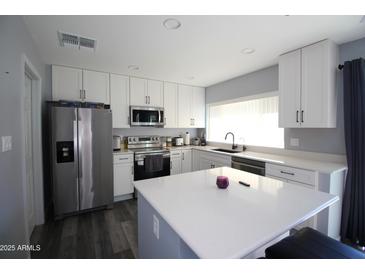 Modern kitchen with stainless steel appliances and white cabinets at 903 W Loughlin Dr, Chandler, AZ 85225