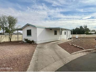 White single-wide manufactured home with carport and gravel landscaping at 9431 E Coralbell Ave, Mesa, AZ 85208