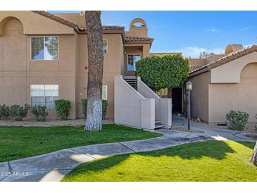 Attractive exterior of a two-story condo building with landscaping and walkways at 10101 N Arabian Trl # 2052, Scottsdale, AZ 85258