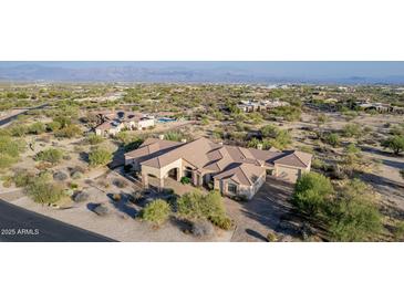 Aerial view of a luxurious house with a large backyard, pool, and mountain views at 14047 E Lowden Ct, Scottsdale, AZ 85262