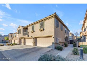 Tan two-story townhome with attached garage and walkway at 1448 N 80Th Dr, Phoenix, AZ 85043