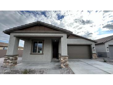 New single-story home with gray exterior, brown accents, and a two-car garage at 15797 W Hackamore Dr, Surprise, AZ 85387