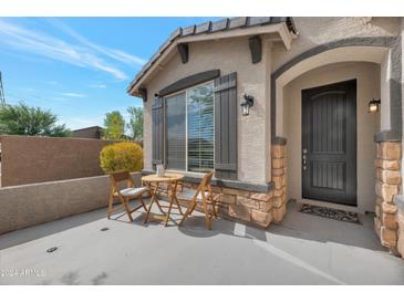 Inviting front exterior with a patio seating area and dark gray front door at 17403 W Eagle Ct, Goodyear, AZ 85338