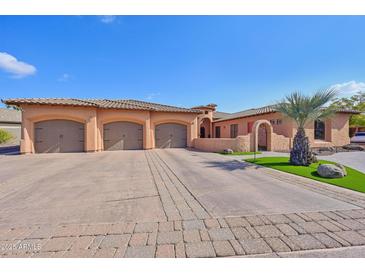 Three-car garage, Spanish-style home with landscaped grounds at 351 N Cloverfield Cir, Litchfield Park, AZ 85340