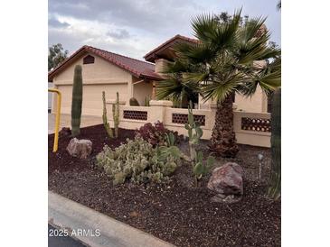 Desert landscaping surrounds this charming home with a two-car garage at 10502 E Spring Creek Rd, Sun Lakes, AZ 85248